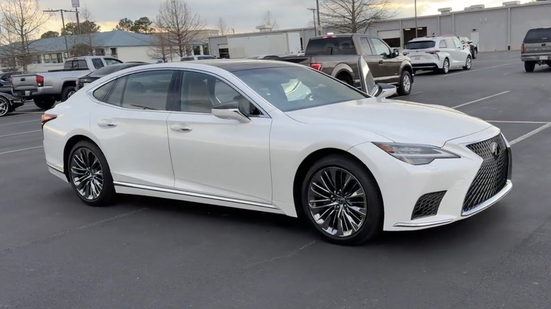 A white 2022 Lexus LS 500 in a dealership parking lot