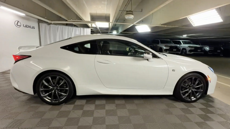 A passenger-side view of a white Lexus RC 300 displayed on a checkered floor