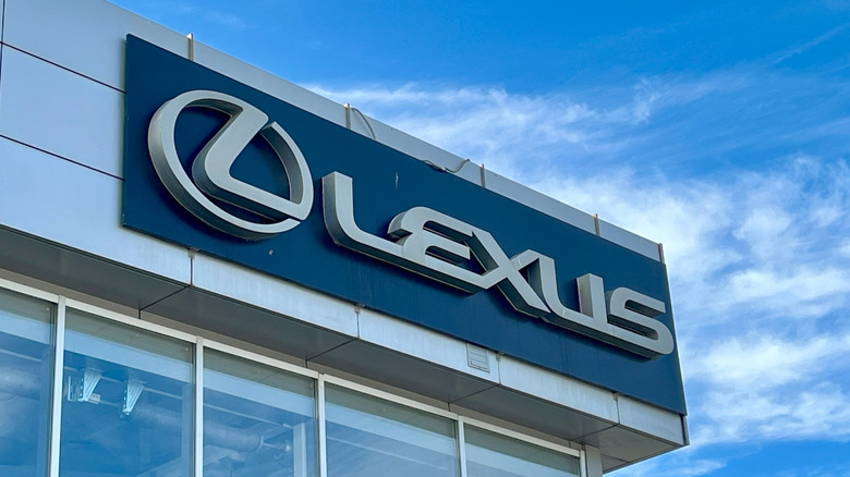 Lexus dealership sign is prominently displayed against a clear blue sky.