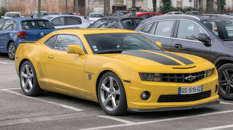 View on a yellow Chevrolet Camaro Transformers Special Edition parked on a parking lot surrounded by other cars.