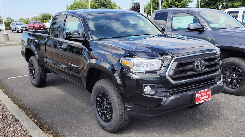 A black 2022 Toyota Tacoma parked next to another pickup truck