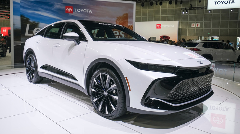 A white 2023 Toyota Crown Hybrid on display at a car show