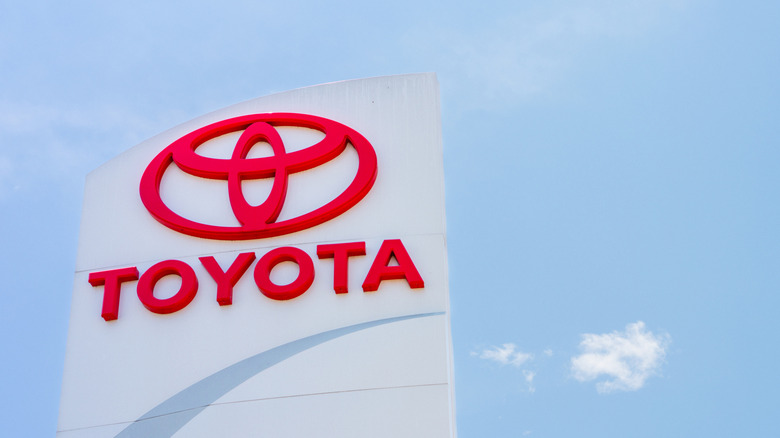 The sign for a Toyota dealership against a clear blue sky