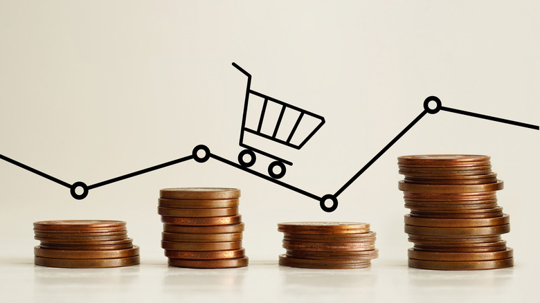 Drawing of shopping cart and line above real stacks of coins