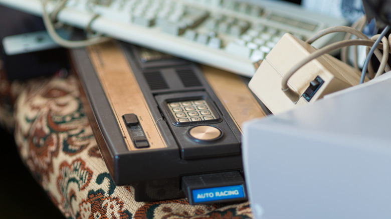 A Mattel Intellivision sitting under a stack of old technology