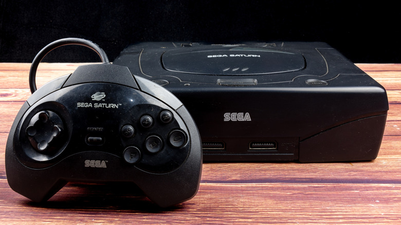 A Sega Saturn sitting on a wood surface