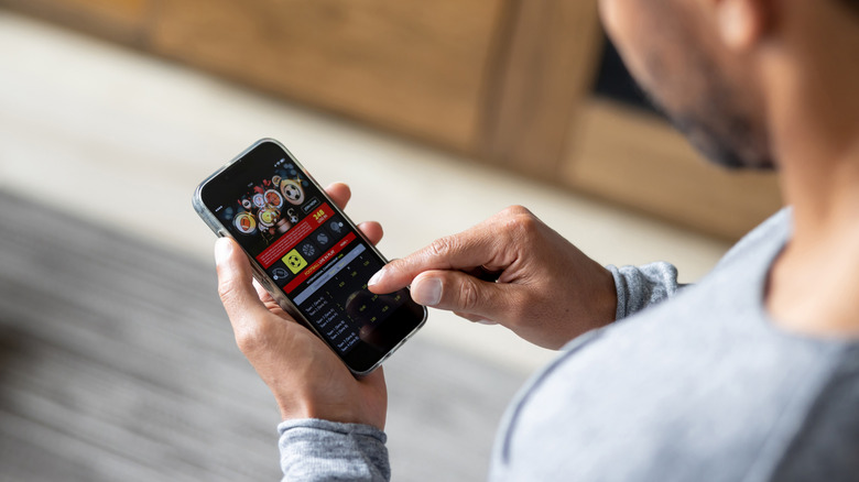 A young man checking the score on a betting app