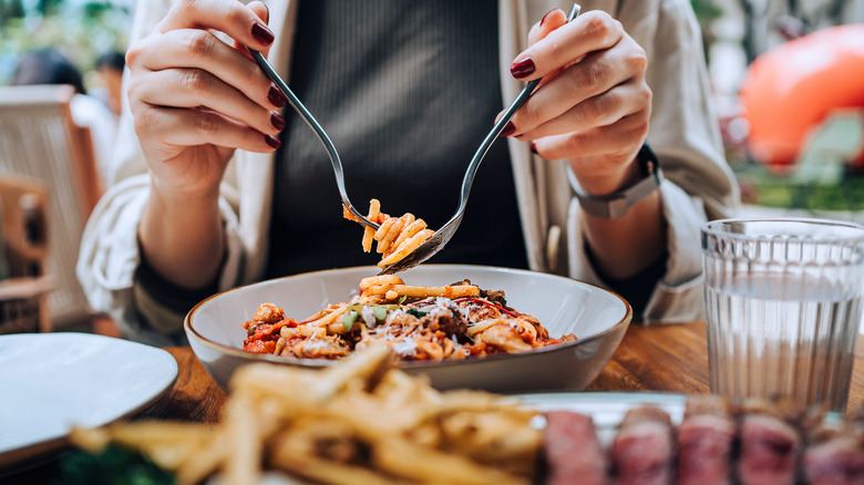 person eating pasta at a table