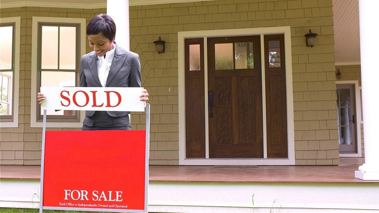 Agent adding "SOLD" house sign