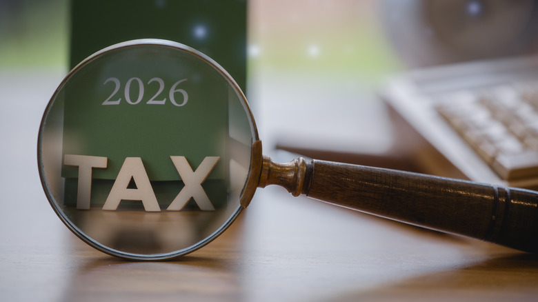 2026 tax concept with magnifying glass highlighting TAX on a green calendar.