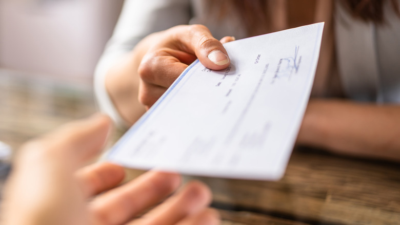 Person hading over check.