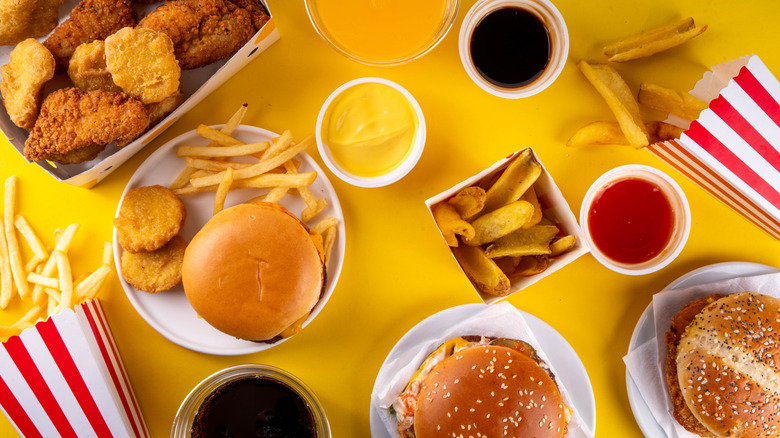 Fast food burgers, fries, nuggets, sauce, and drinks
