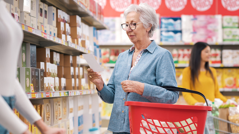 Older woman checking shopping list in store