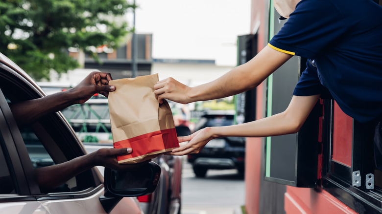 Man in car receiving an order in drive-thru restaurant