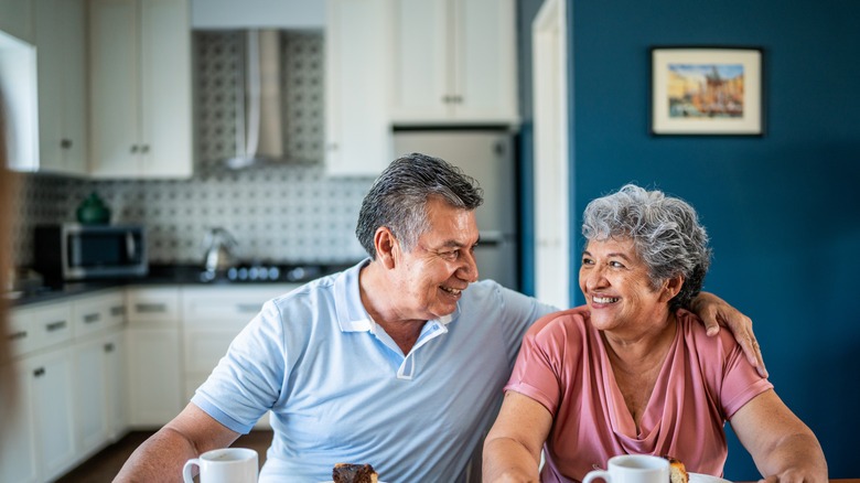 Happy older couple eating breakfast at home
