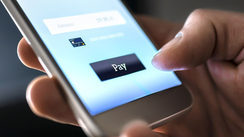 photo of mobile payment application with blurred amount and black "Pay" action button