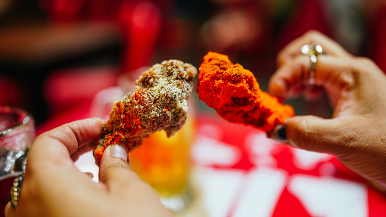 Person holding two different kinds of chicken wings