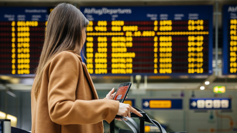 Passenger looking at airport departures screen