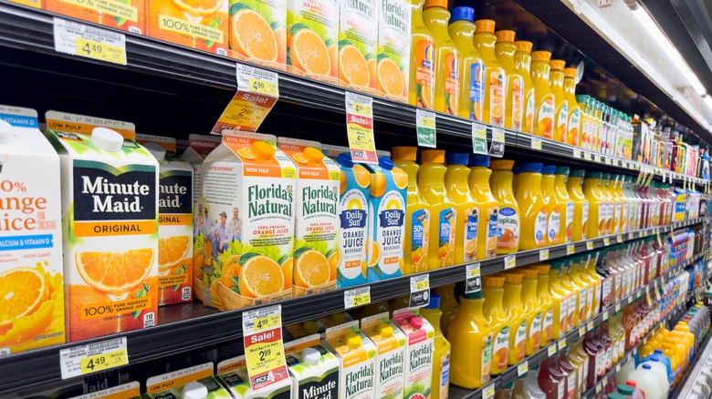 Assorted orange juice containers for sale in grocery store