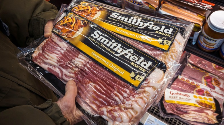 A shopper chooses packages of Smithfield brand bacon in a supermarket in advance of their IPO.