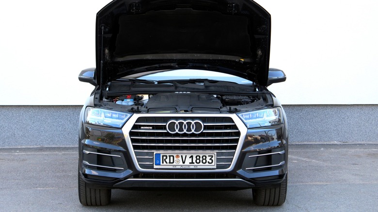 Front view of a black Audi Q7 with its hood open, showing part of the engine bay