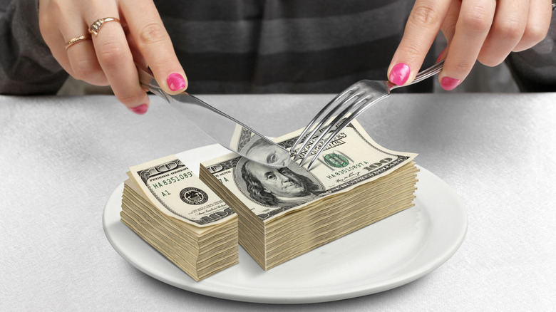 Hands cutting money on a plate to illustrate segmented funds