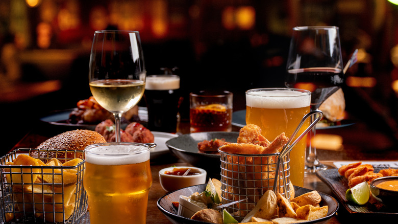 A dinner banquet with prawns finger food portions on a table set with starters beers wines drinks