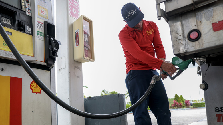 A young man filling his vehicle with diesel fuel