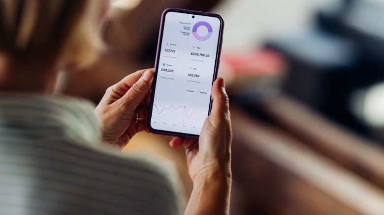 A woman looking at robo-advisor market information on a phone app.
