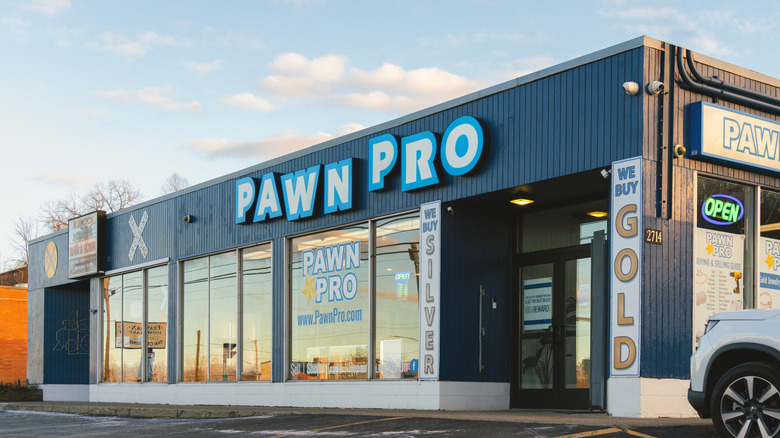 The front of a pawn shop with signs advertising that it buys gold and silver