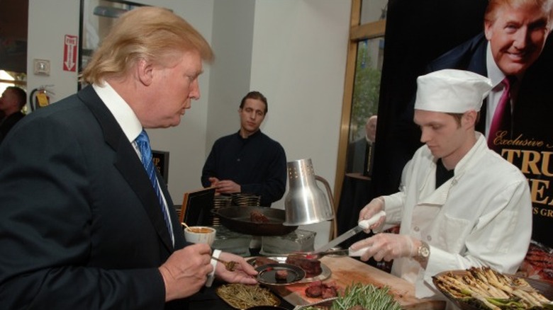 Donald Trump sampling steak during the launch of Trump Steaks event in 2006.