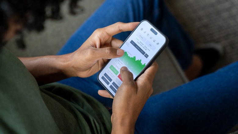 Person checking stock prices on a smartphone