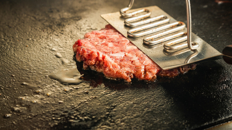 a smashed hamburger patty on a grill