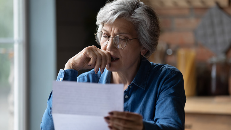 Woman looking distressed while reading a letter