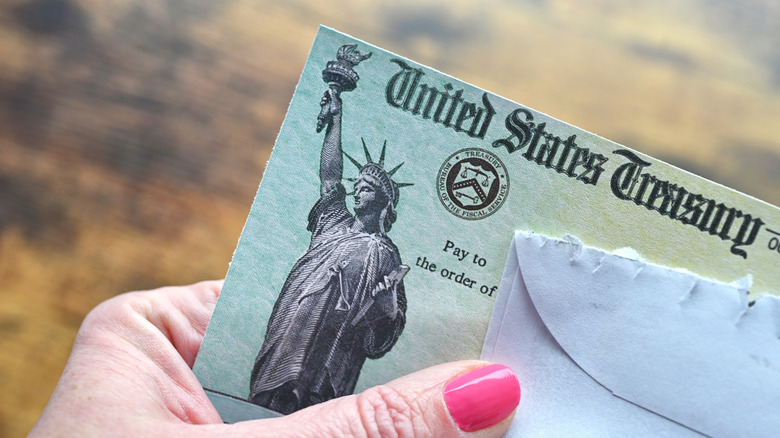 Person holding social security check.