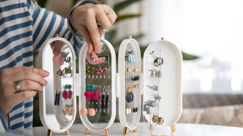 Hands displaying collection of jewelry