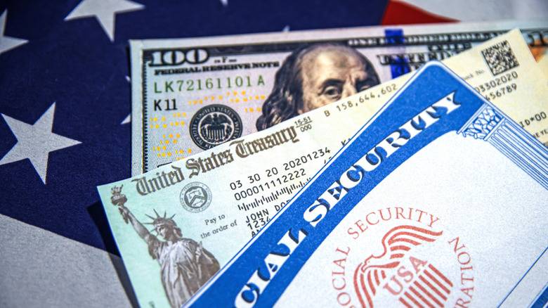 Treasury Check and Dollar Bill concept placed on the American Flag, close up view background.