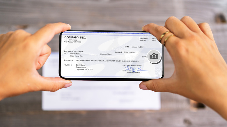 An employee taking a photo of their paycheck to make a mobile deposit