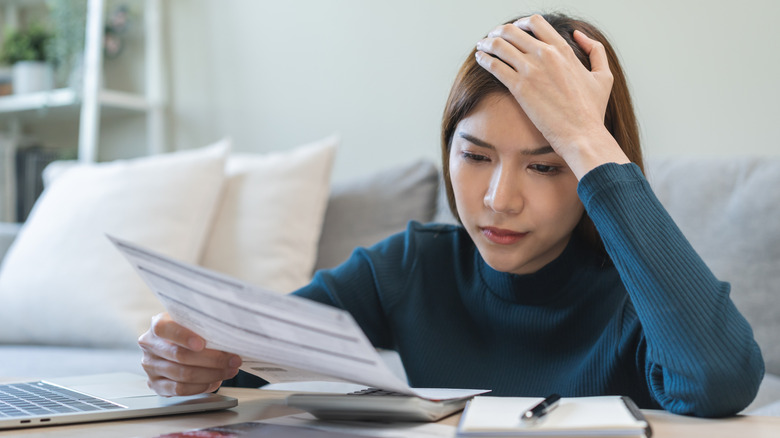 stressed out young woman paying her credit card bill