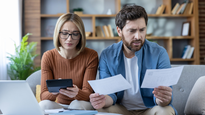 A couple stressed out about bills in their living room