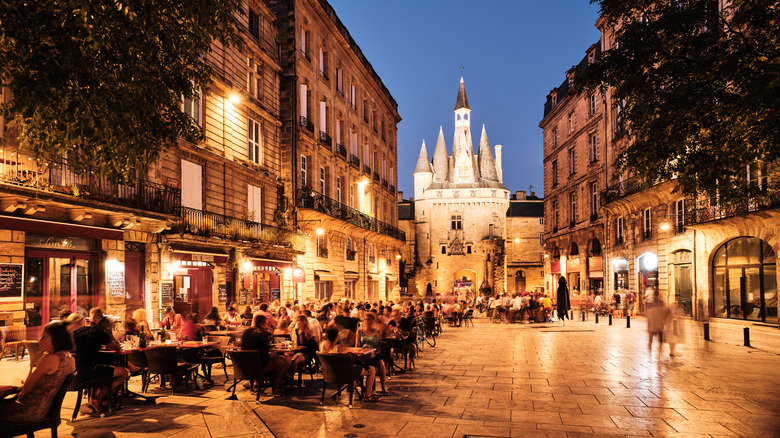 French cafes and restaurants lining street in front of castle