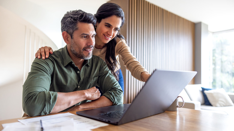 Couple looking at a laptop computer.