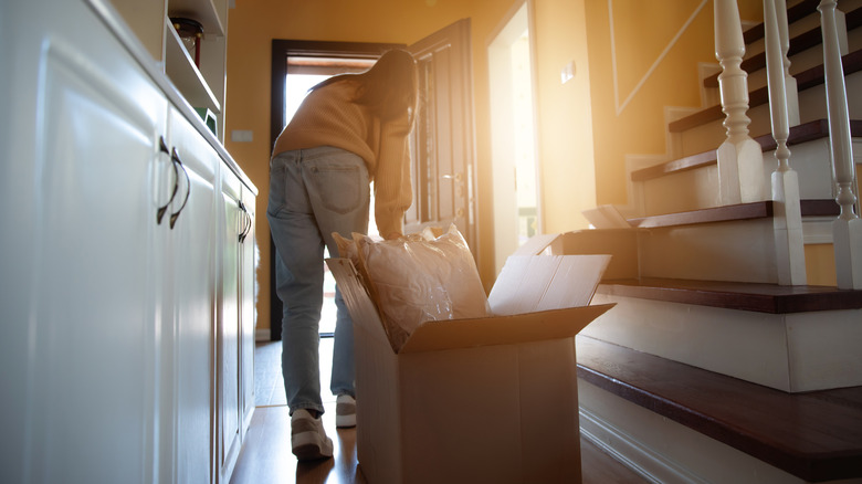 Person dragging box with moving supplies inside.