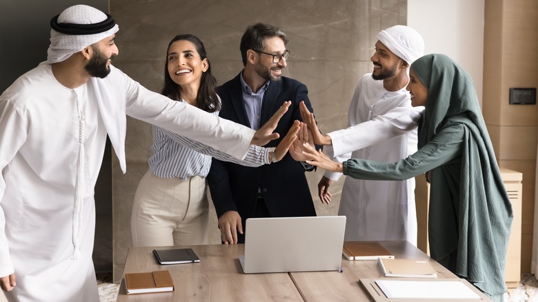 Group of people doing a high five gesture in meeting