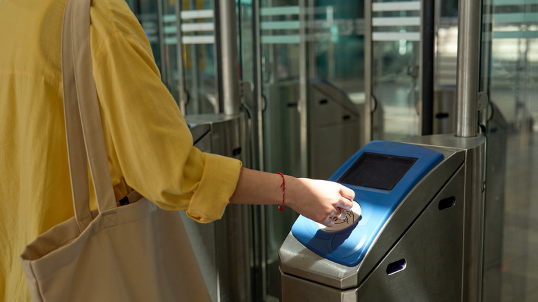Someone paying for entry at a train station.