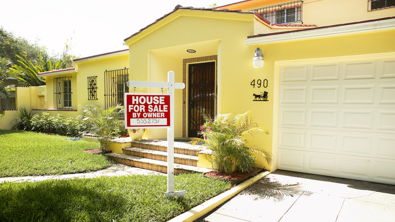 Yellow house with house for sale by owner sign