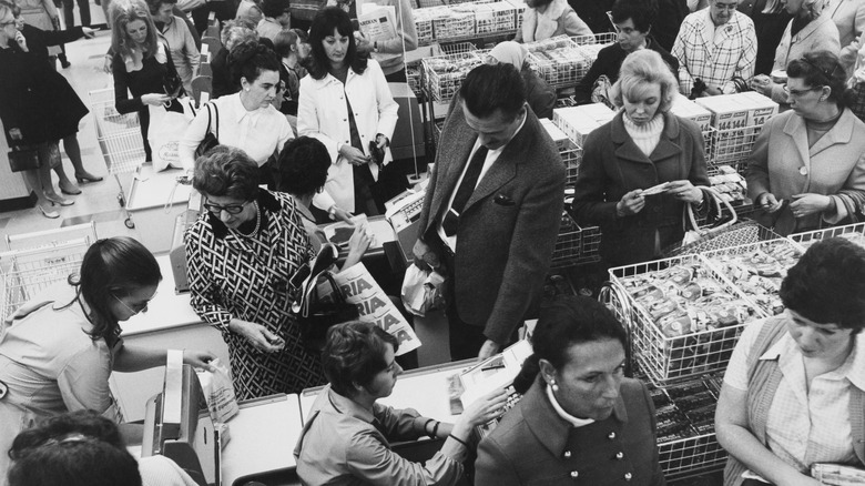 Black and white photo showing people shopping in the 1970s