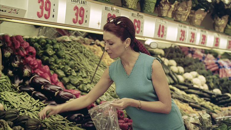 Woman in 1970s grocery shopping in produce isle