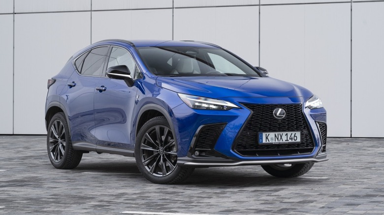 Blue hybrid Lexus NX SUV parked in front of a gray wall