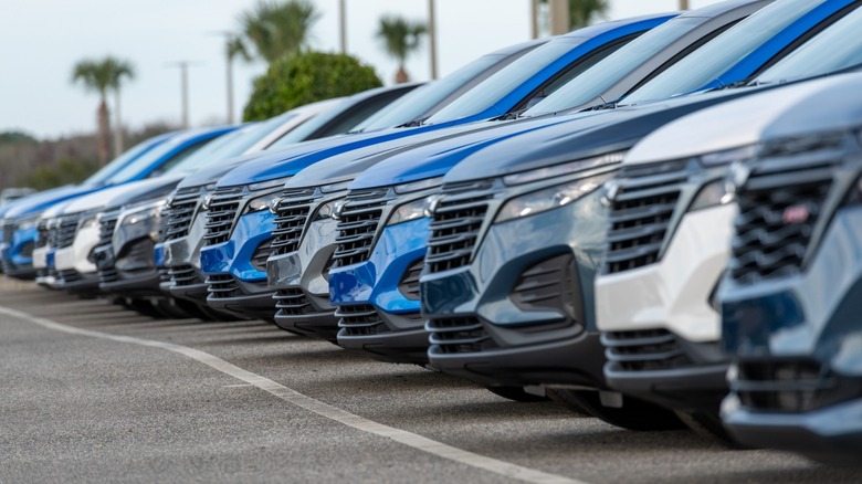 A row of blue, white, and gray cars